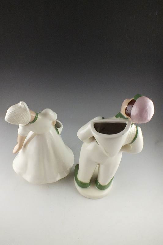 A pair of slip cast ceramic Dutch Boy and Girl planter figurines signed by California artist, Hedi Schoop circa  1950's