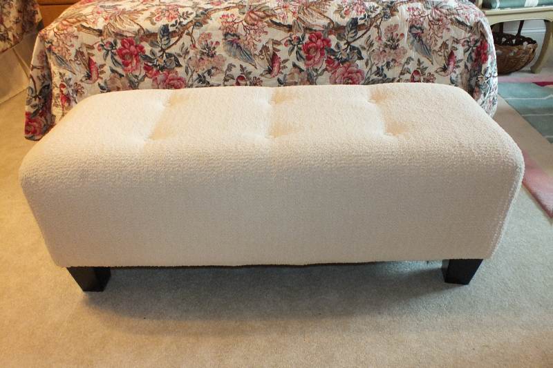 A Contemporary ottoman with button tufted seat upholstered in a soft white cotton chenille fabric