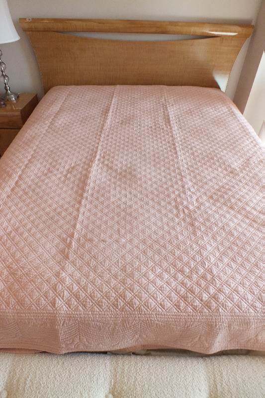 A pair of quilted dusty rose coverlets