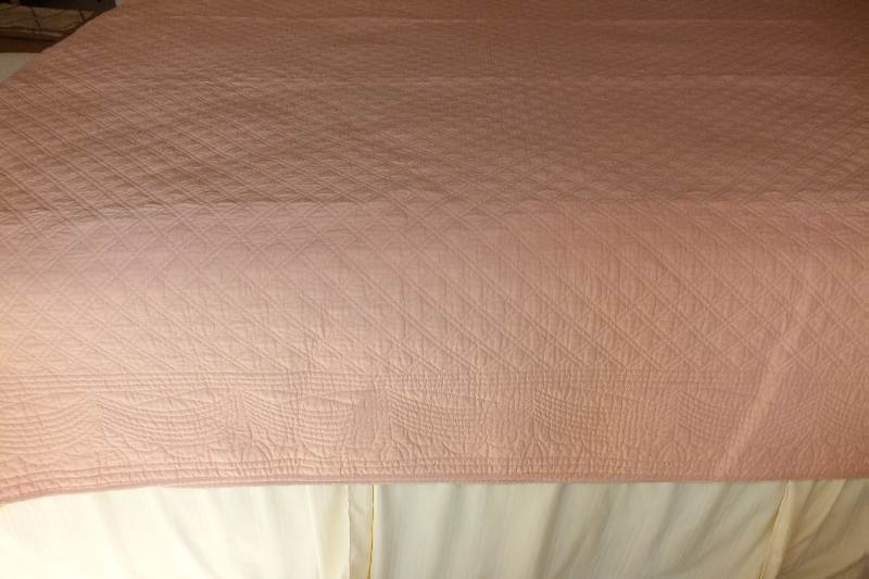A pair of quilted dusty rose coverlets