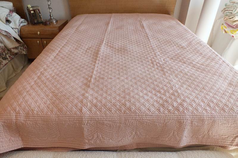 A pair of quilted dusty rose coverlets
