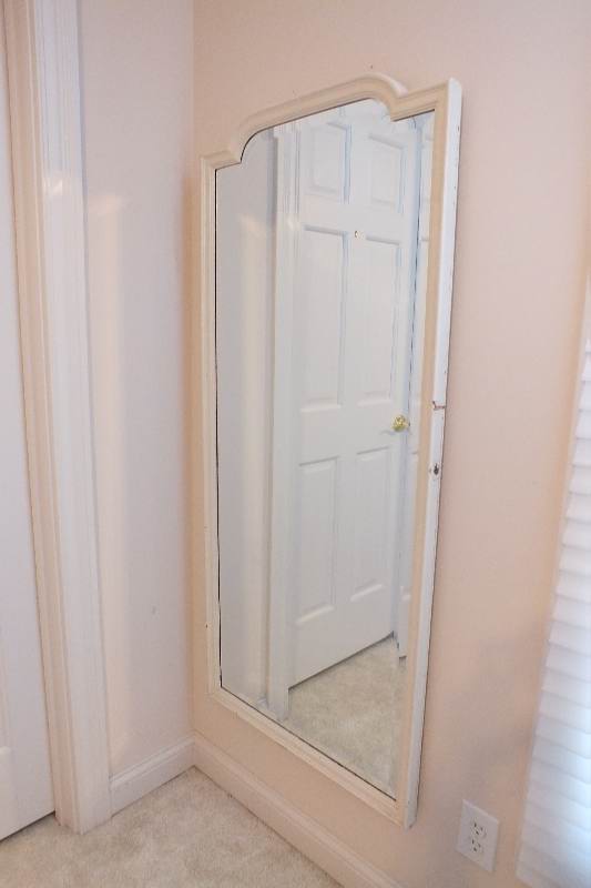 A painted wood framed beveled edge mirror repurposed as a wall unit