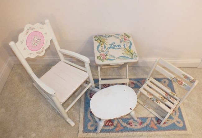 A cute set of furniture which consists of a white wood rocker from Kidcraft, a folding table with a painted "love" design, a vintage wood footstool-nice for reaching the sink, a folding chair stool with hand painted floral appliqués and a small hook rug h