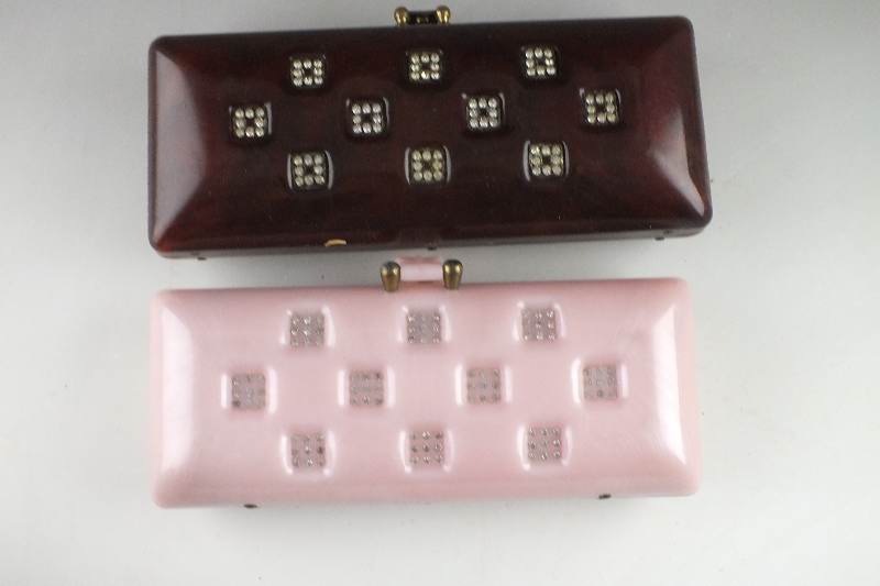 A lovely pink acrylic clutch style purse and a similar style dark amber acrylic purse