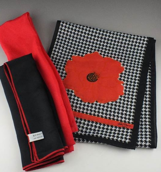 A trio of silk scarves which includes a black, white and red patterned scarf designed by Jim Renoir, Paris; a black scarf with red border from Echo and a vibrant Chinese red scarf