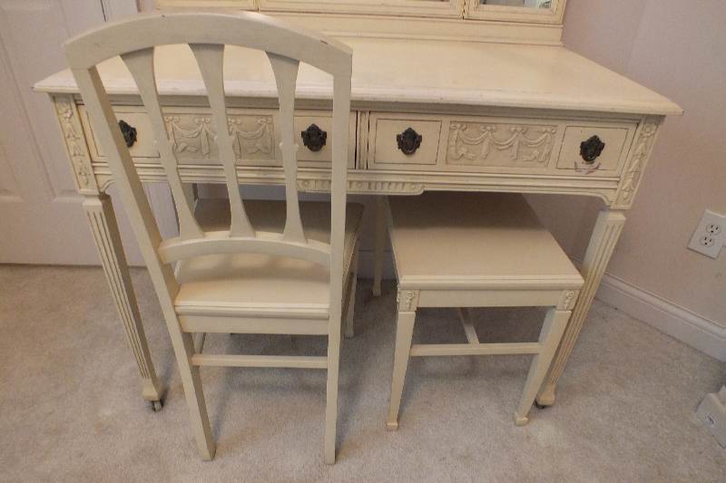 An Italianate style vanity / dressing table with two center dovetail constructed drawers detailed with carved swags and bows