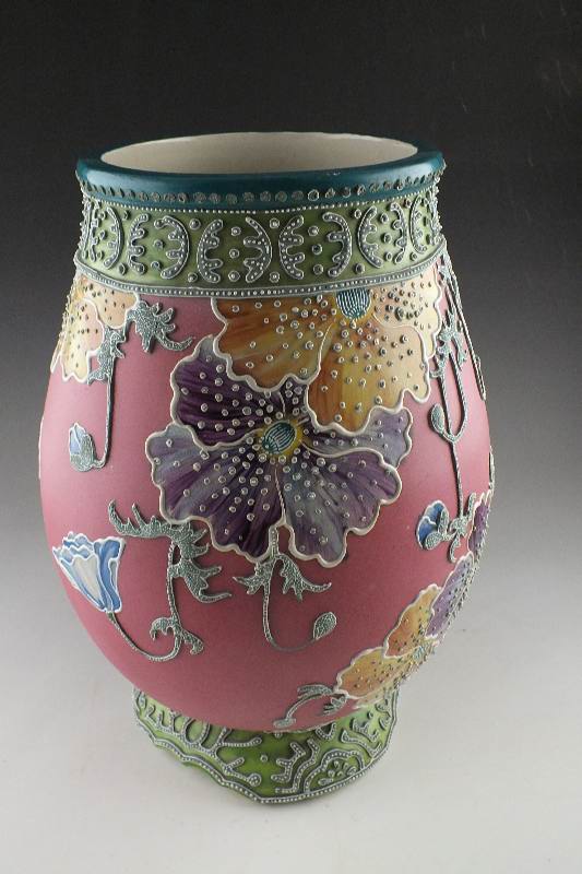 A hand painted and decorated Moriage Lamp in tinted hues of green red blue and grey