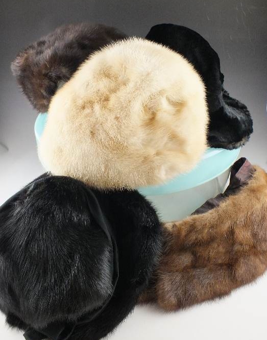 A group of assorted vintage fur Ladies hats in many styles and fur types all are nestled in an acrylic hat box