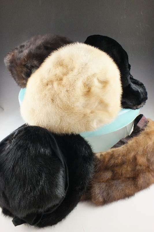 A group of assorted vintage fur Ladies hats in many styles and fur types all are nestled in an acrylic hat box