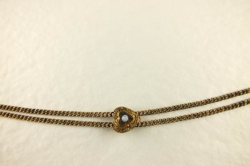 A gold toned Victorian slide necklace with hook clasp marked SHX5