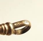 A gold toned Victorian slide necklace with hook clasp marked SHX5