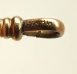 A gold toned Victorian slide necklace with hook clasp marked SHX5