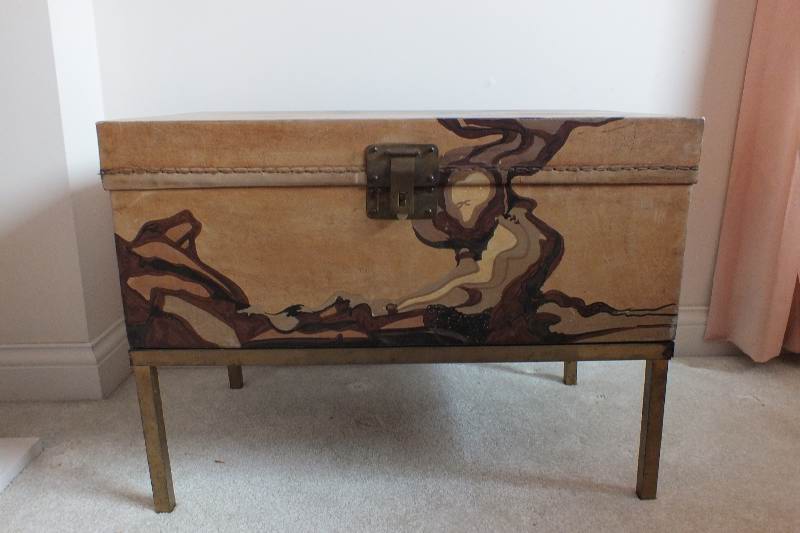 A painted leather like chest in the style of an Asian bride's trunk with two side handles