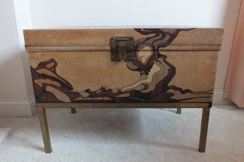 A painted leather like chest in the style of an Asian bride's trunk with two side handles