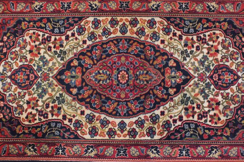 A semi antique hand woven wool and silk oriental style rug