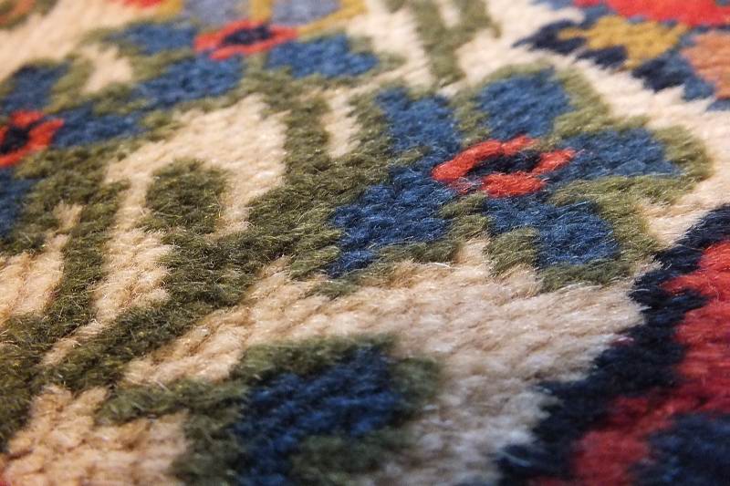 A semi antique hand woven wool and silk oriental style rug