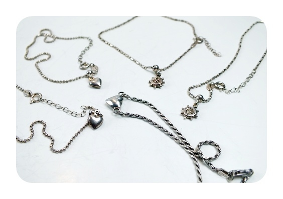 Six sterling bracelets with small charms attached.