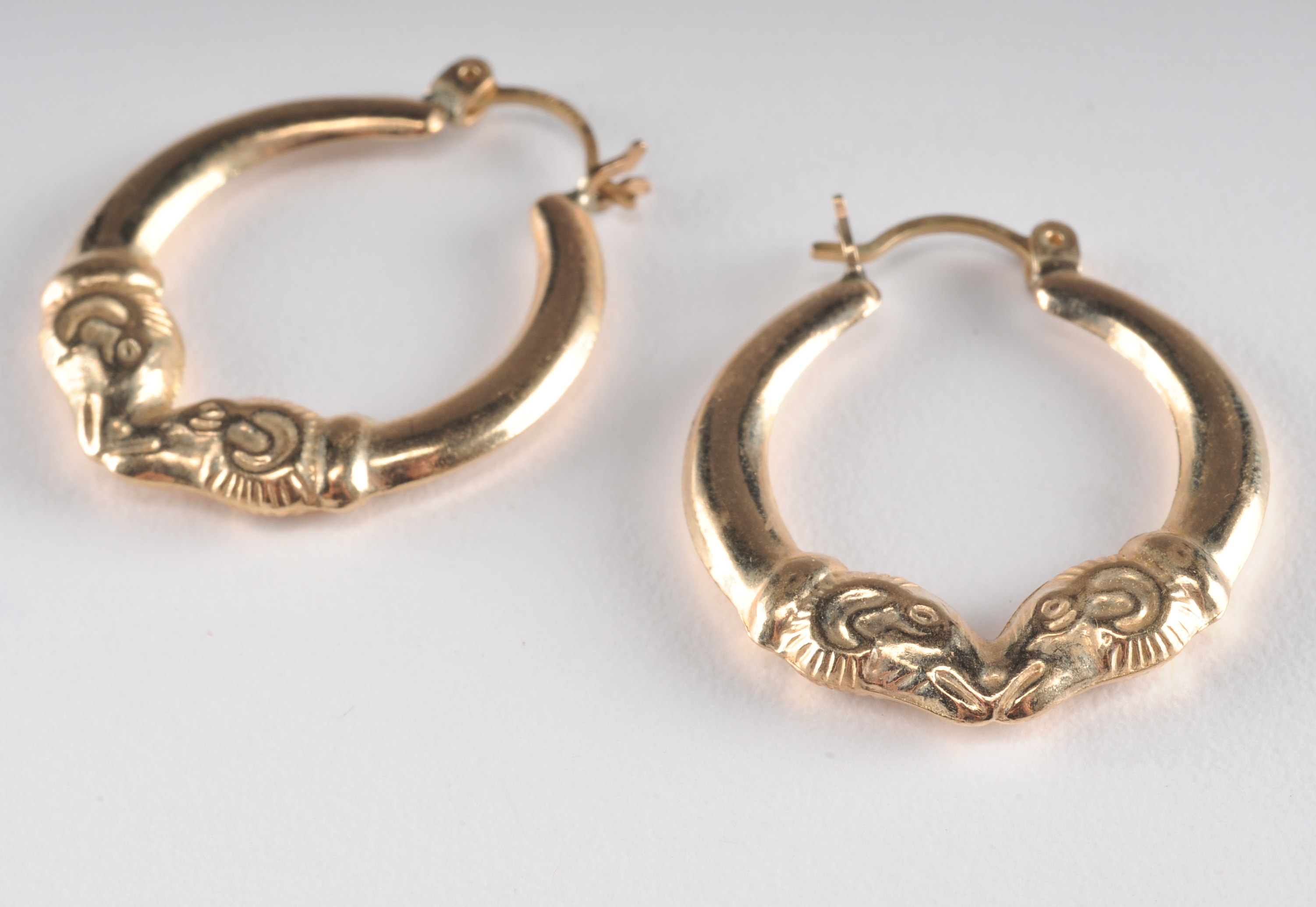 14 K yellow gold loop earrings with Rams head 
