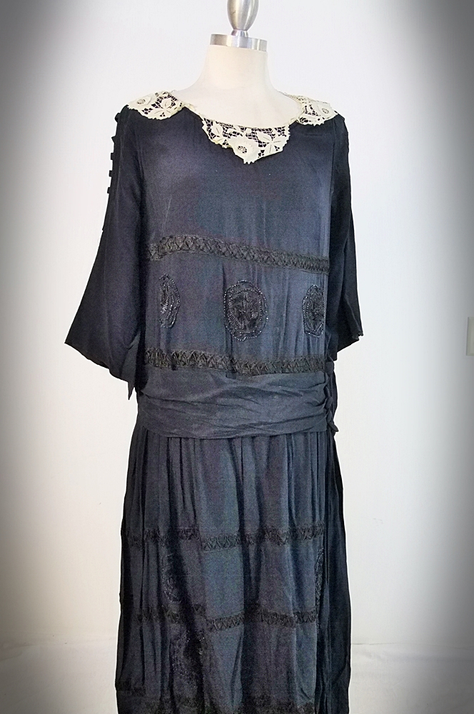 Early 20th Century black dress embellished with black hand embroidered silk and hand beaded jet black glass medallions