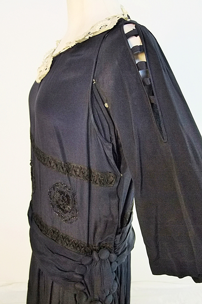 Early 20th Century black dress embellished with black hand embroidered silk and hand beaded jet black glass medallions