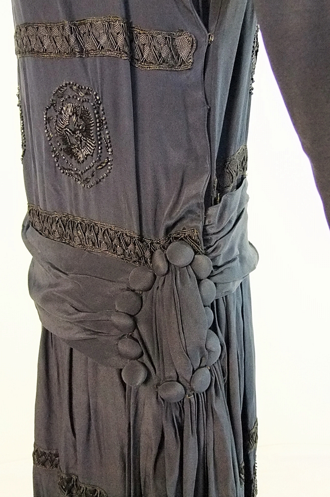 Early 20th Century black dress embellished with black hand embroidered silk and hand beaded jet black glass medallions