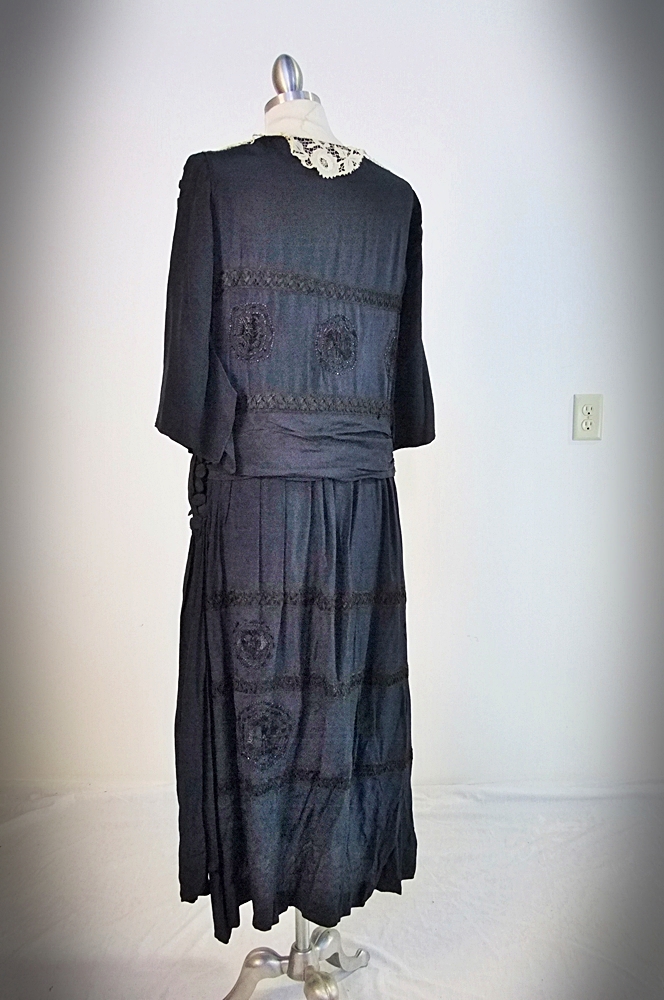 Early 20th Century black dress embellished with black hand embroidered silk and hand beaded jet black glass medallions