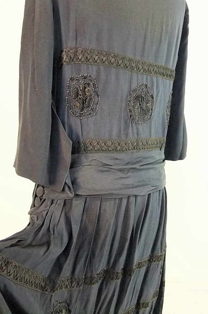 Early 20th Century black dress embellished with black hand embroidered silk and hand beaded jet black glass medallions