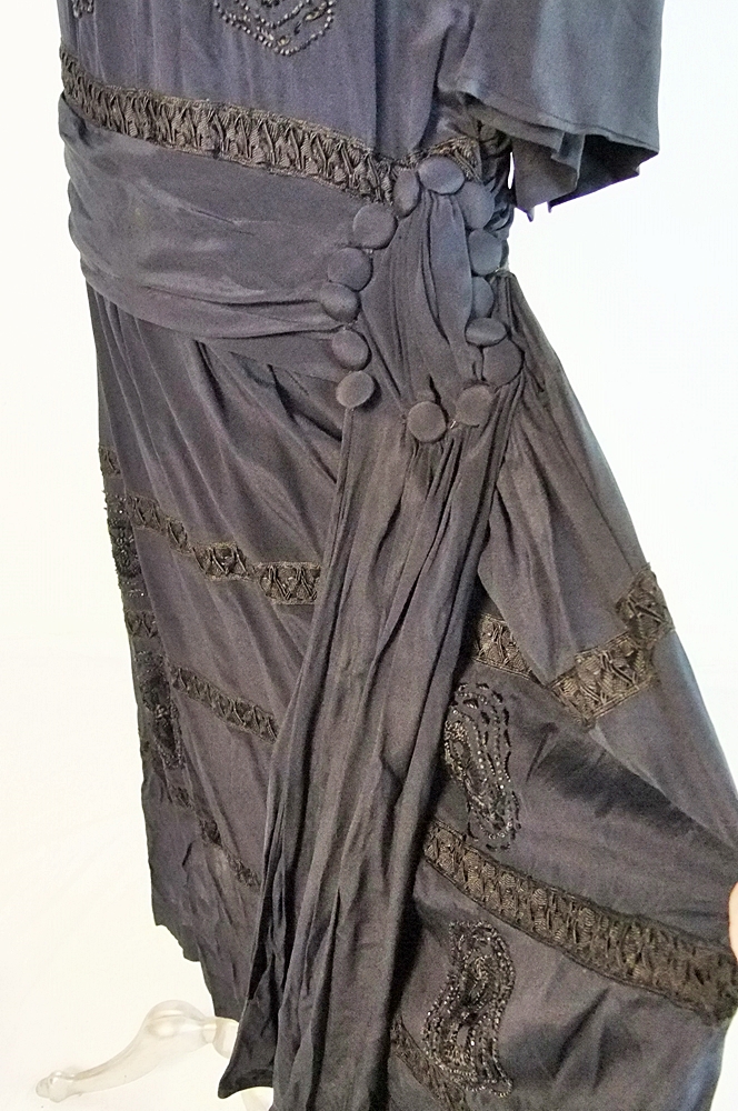 Early 20th Century black dress embellished with black hand embroidered silk and hand beaded jet black glass medallions
