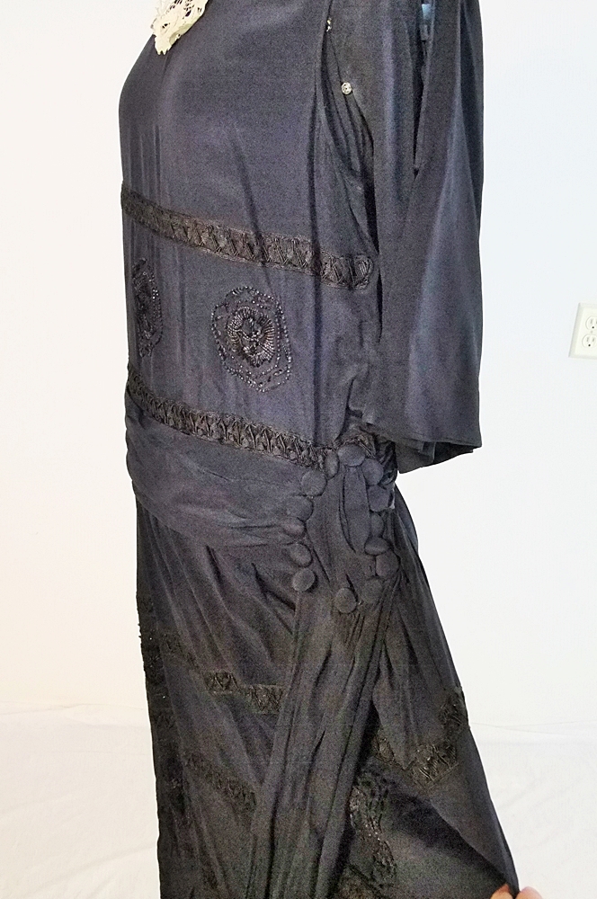 Early 20th Century black dress embellished with black hand embroidered silk and hand beaded jet black glass medallions