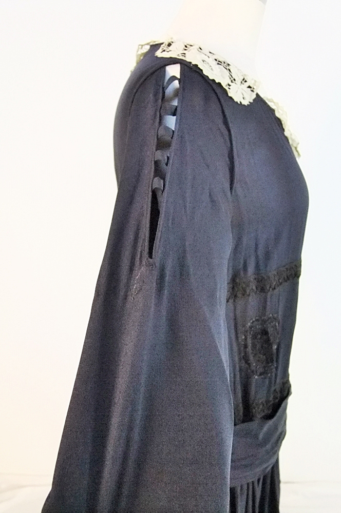 Early 20th Century black dress embellished with black hand embroidered silk and hand beaded jet black glass medallions