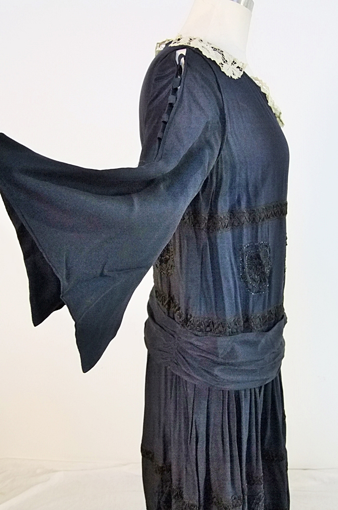 Early 20th Century black dress embellished with black hand embroidered silk and hand beaded jet black glass medallions
