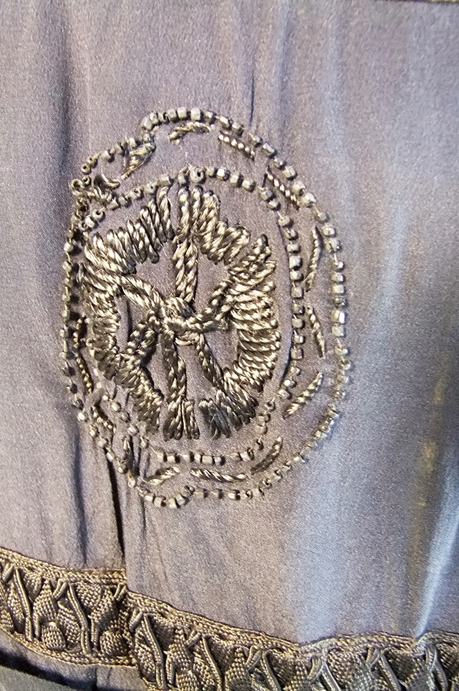 Early 20th Century black dress embellished with black hand embroidered silk and hand beaded jet black glass medallions