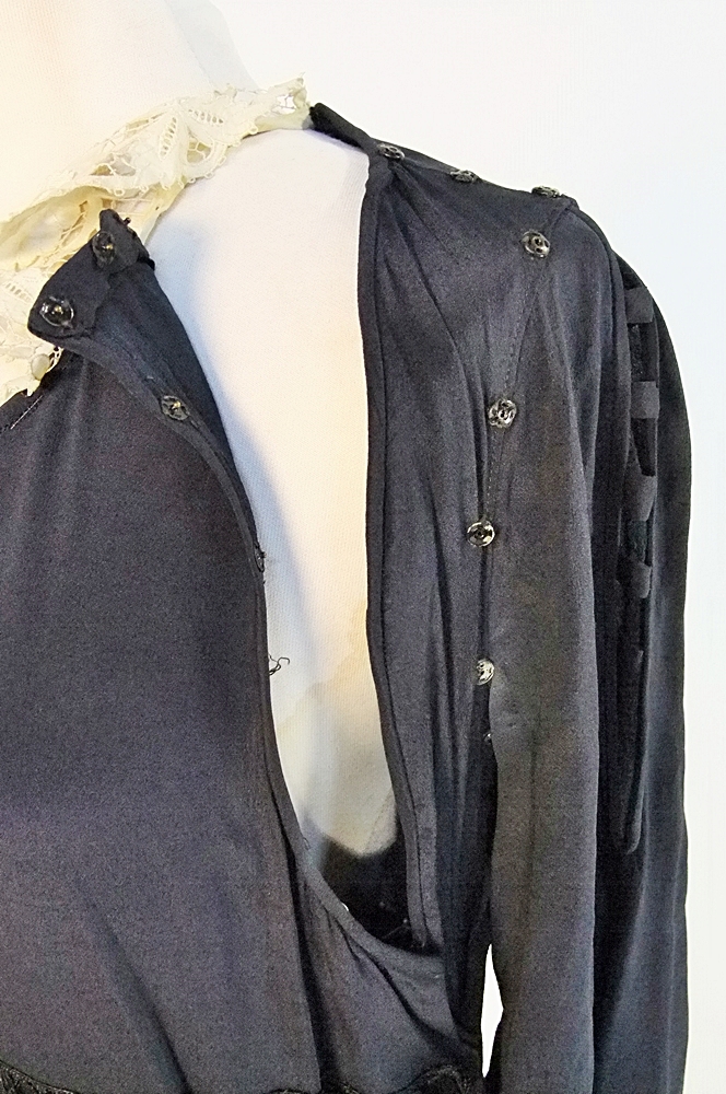Early 20th Century black dress embellished with black hand embroidered silk and hand beaded jet black glass medallions