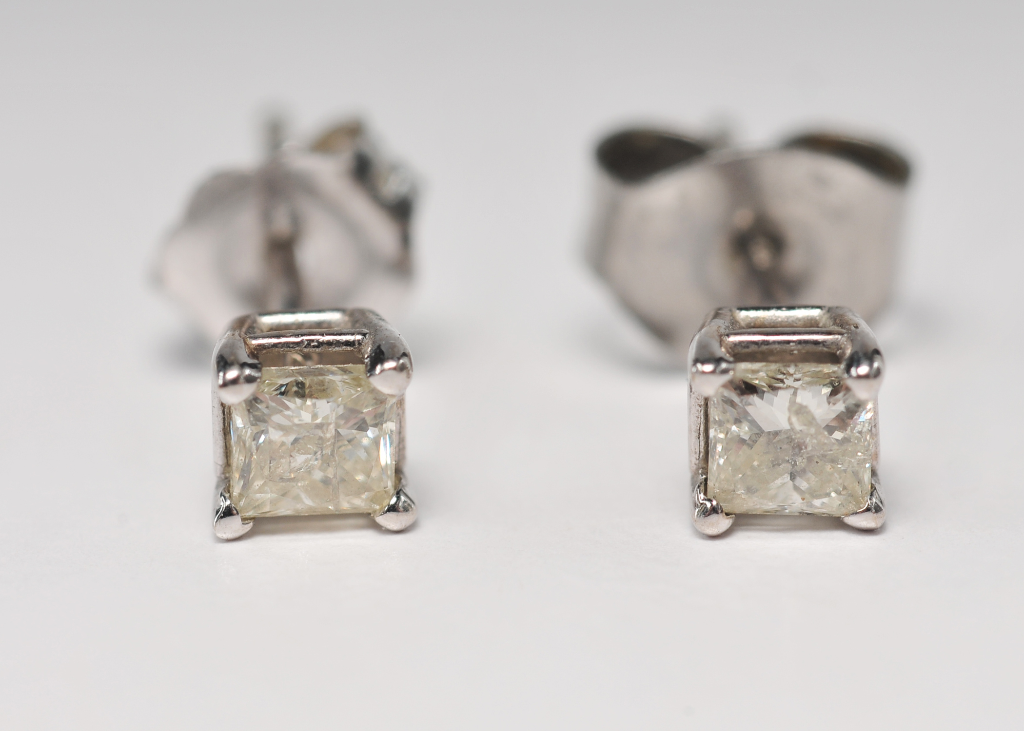 Pair of 14 K white gold and square cut diamond stud earrings 