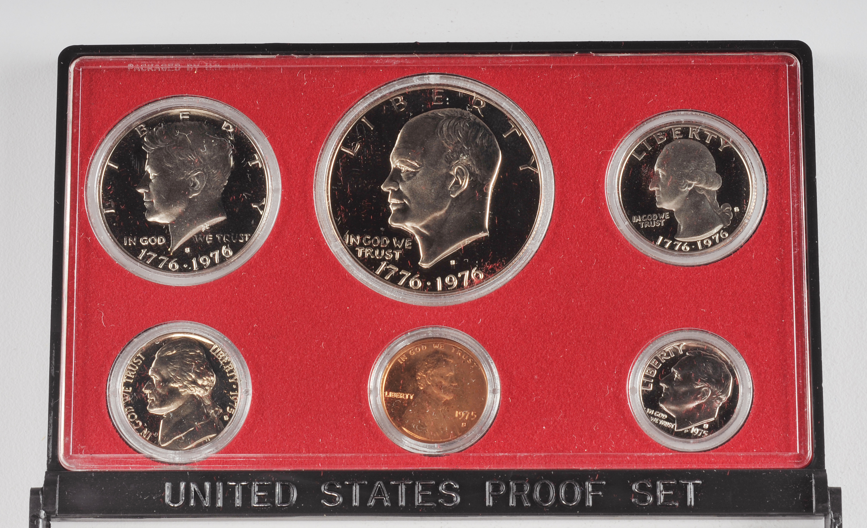 1975 U.S. Proof set including Eisenhower dollar, JFK half dollar, Washington quarter, Roosevelt dime, Jefferson nickel, and Lincoln penny