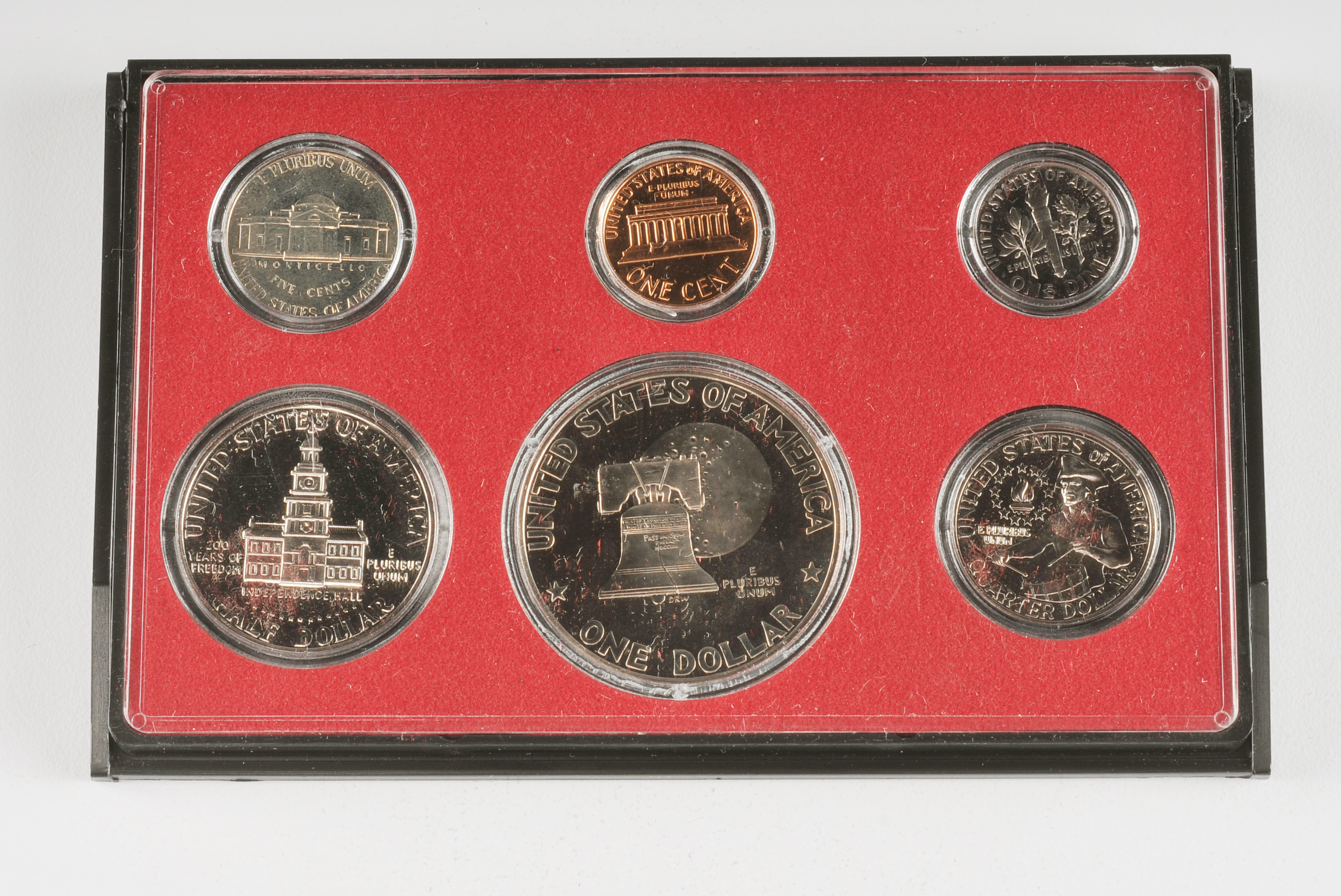 1975 U.S. Proof set including Eisenhower dollar, JFK half dollar, Washington quarter, Roosevelt dime, Jefferson nickel, and Lincoln penny