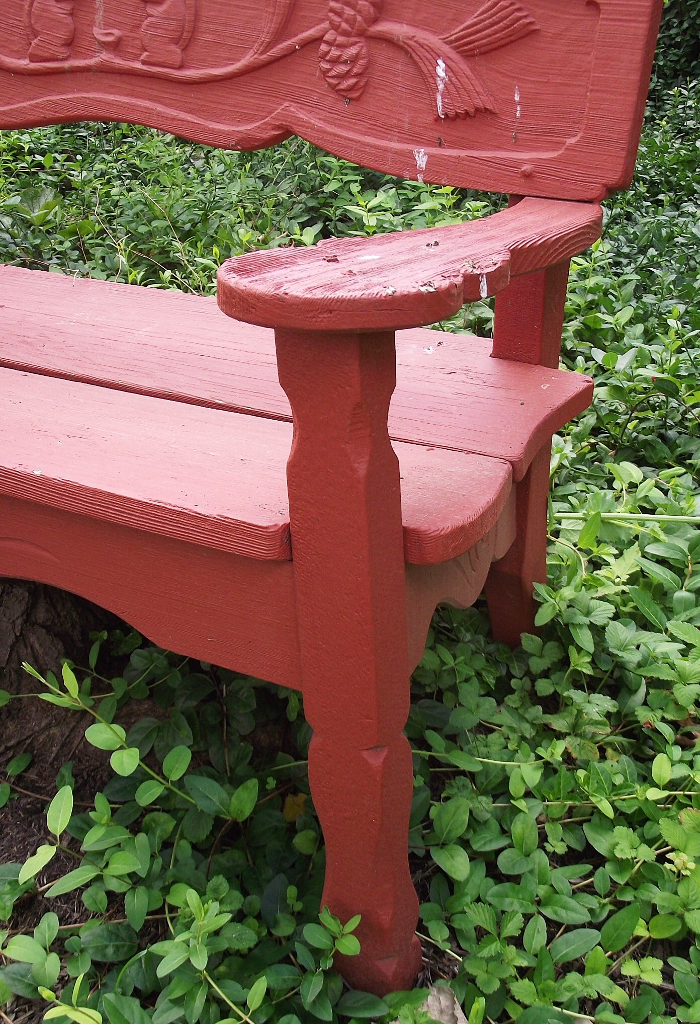 Vintage wooden garden bench with carved squirrel motif.