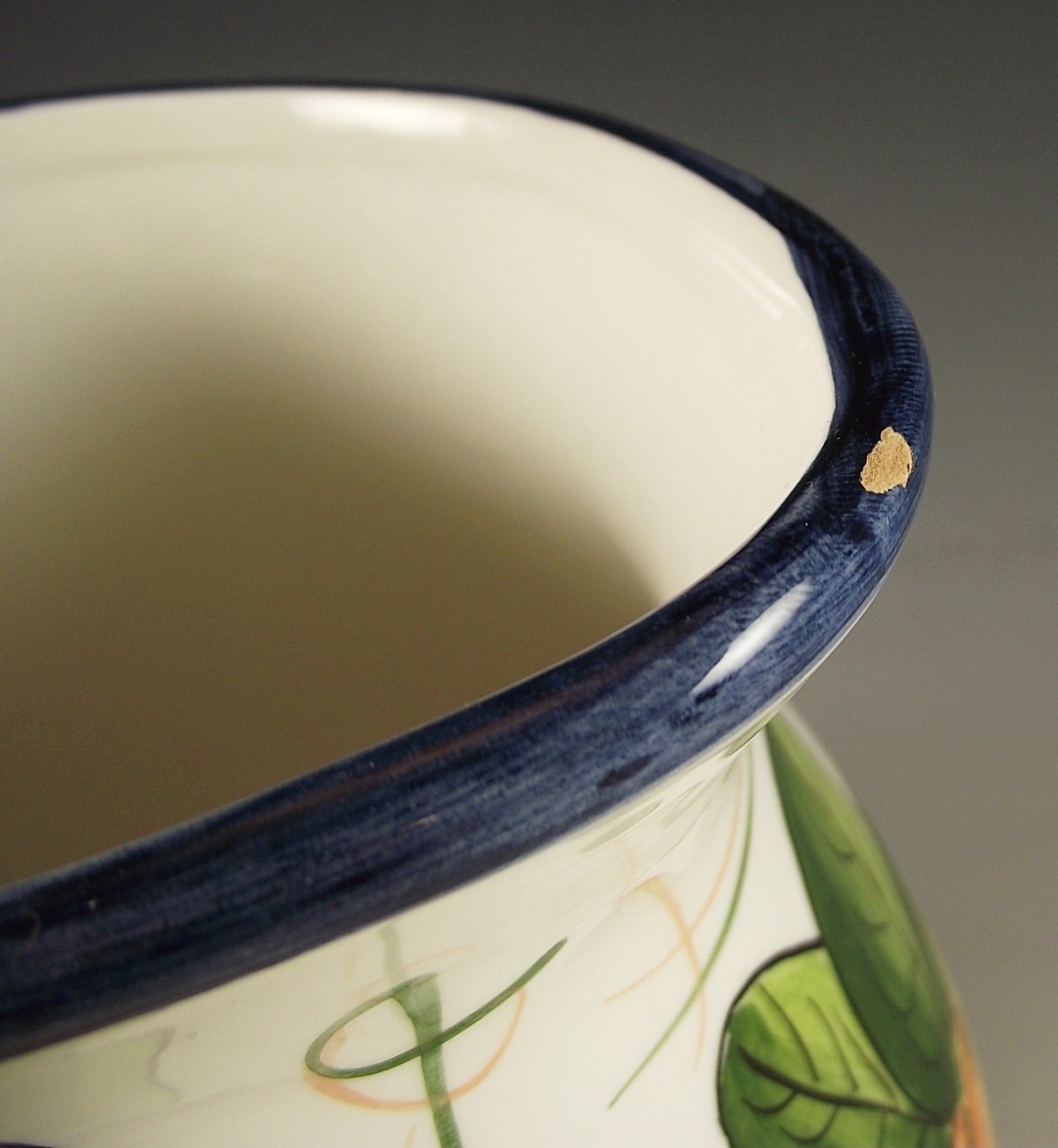 Three ceramic pitchers with painted designs.