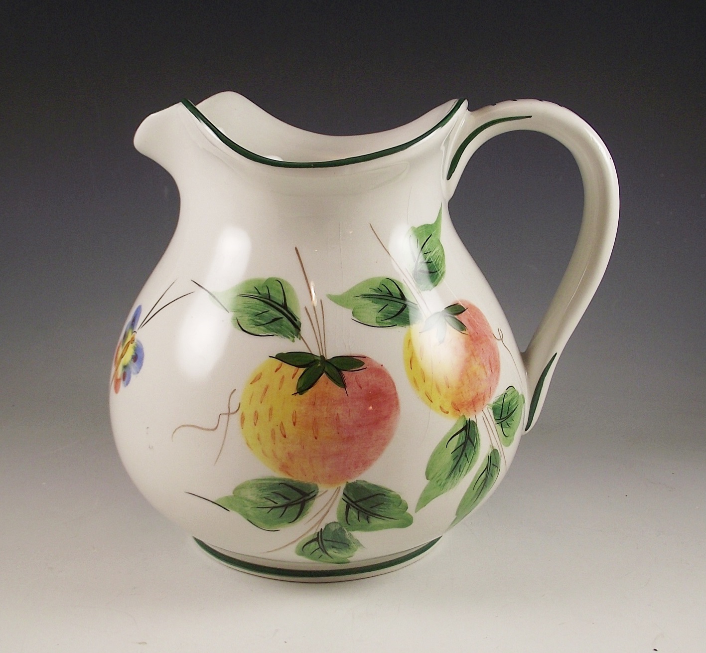 Three ceramic pitchers with painted designs.