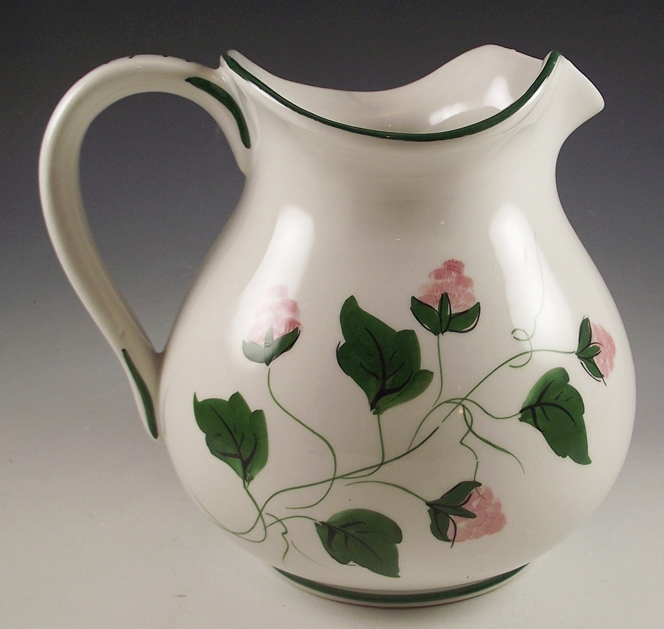 Three ceramic pitchers with painted designs.