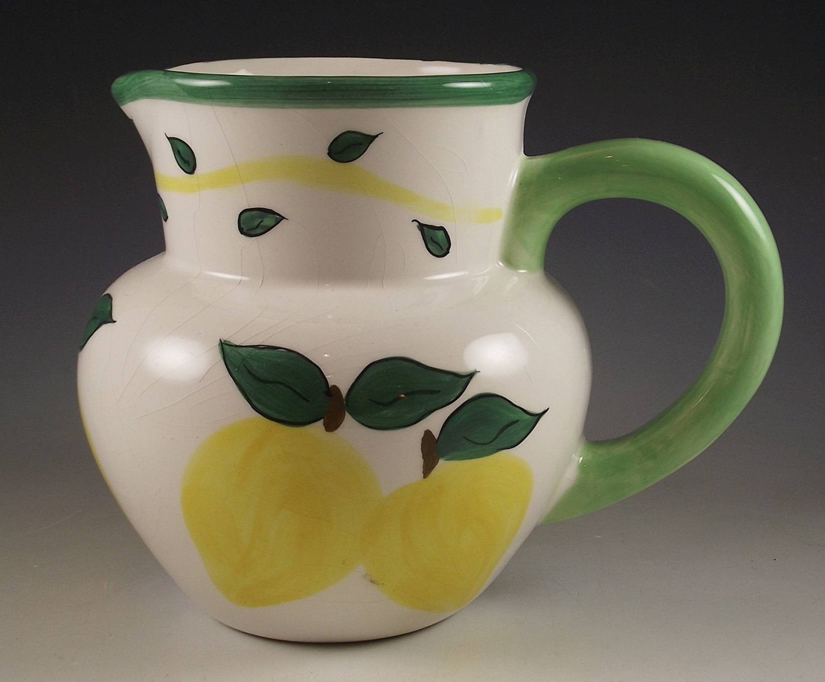 Three ceramic pitchers with painted designs.