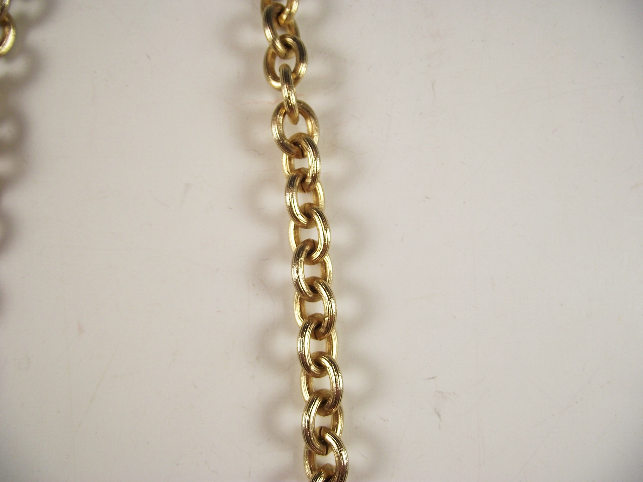 Four gold tone necklaces.