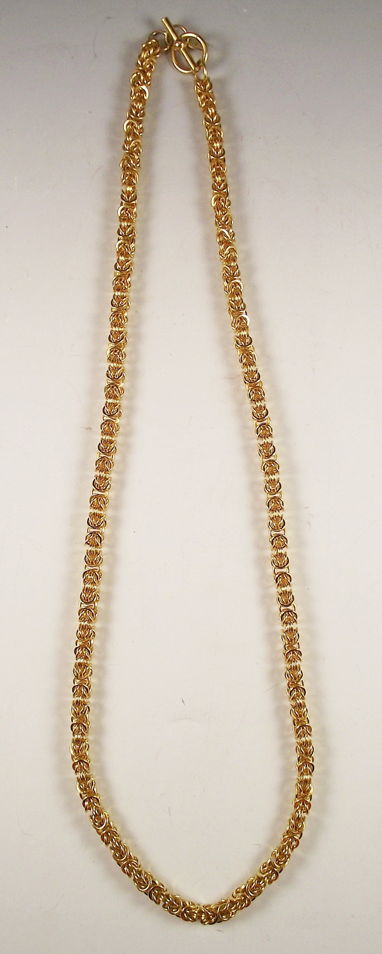 Four gold tone necklaces.