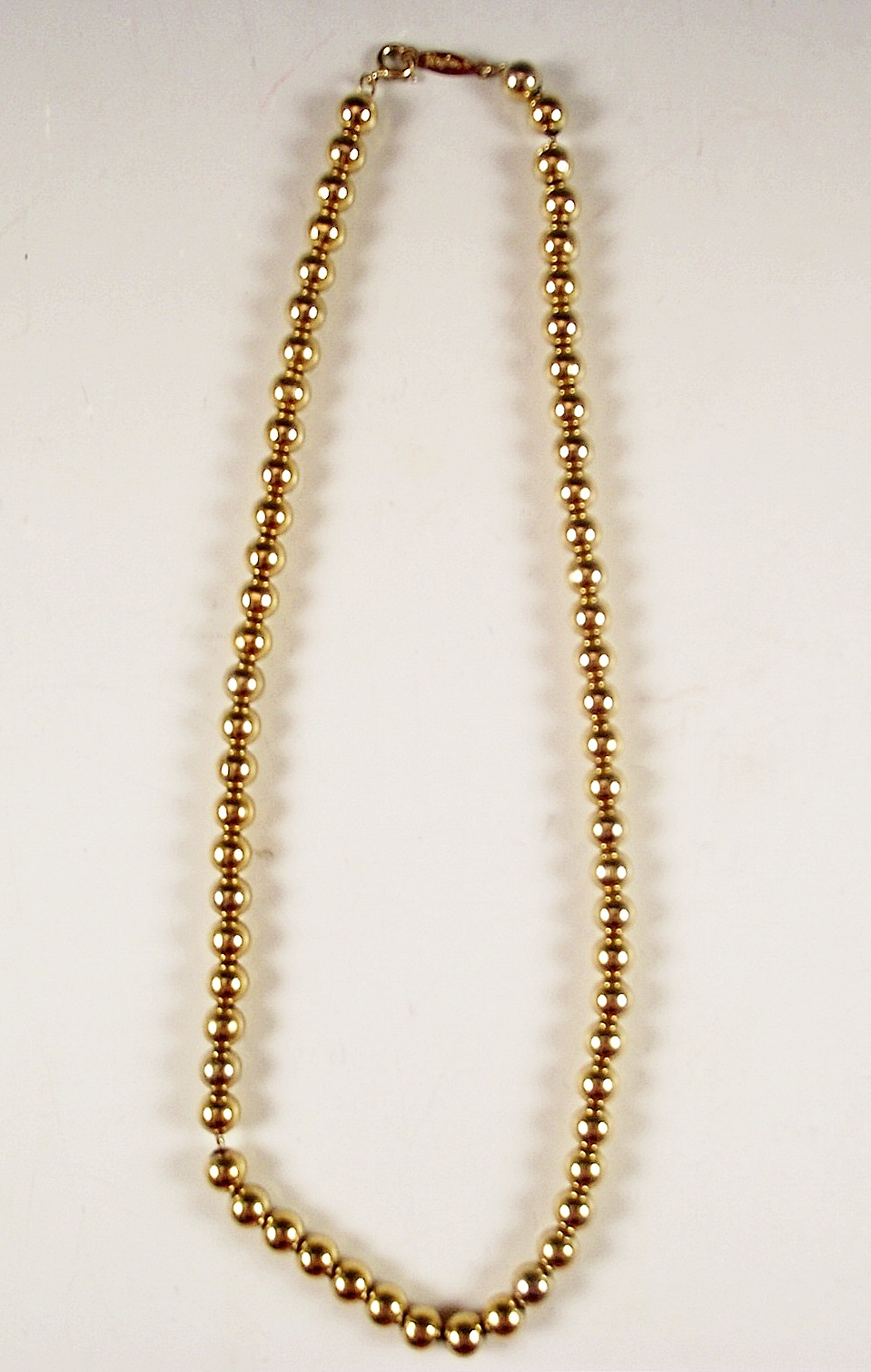 Four gold tone necklaces.