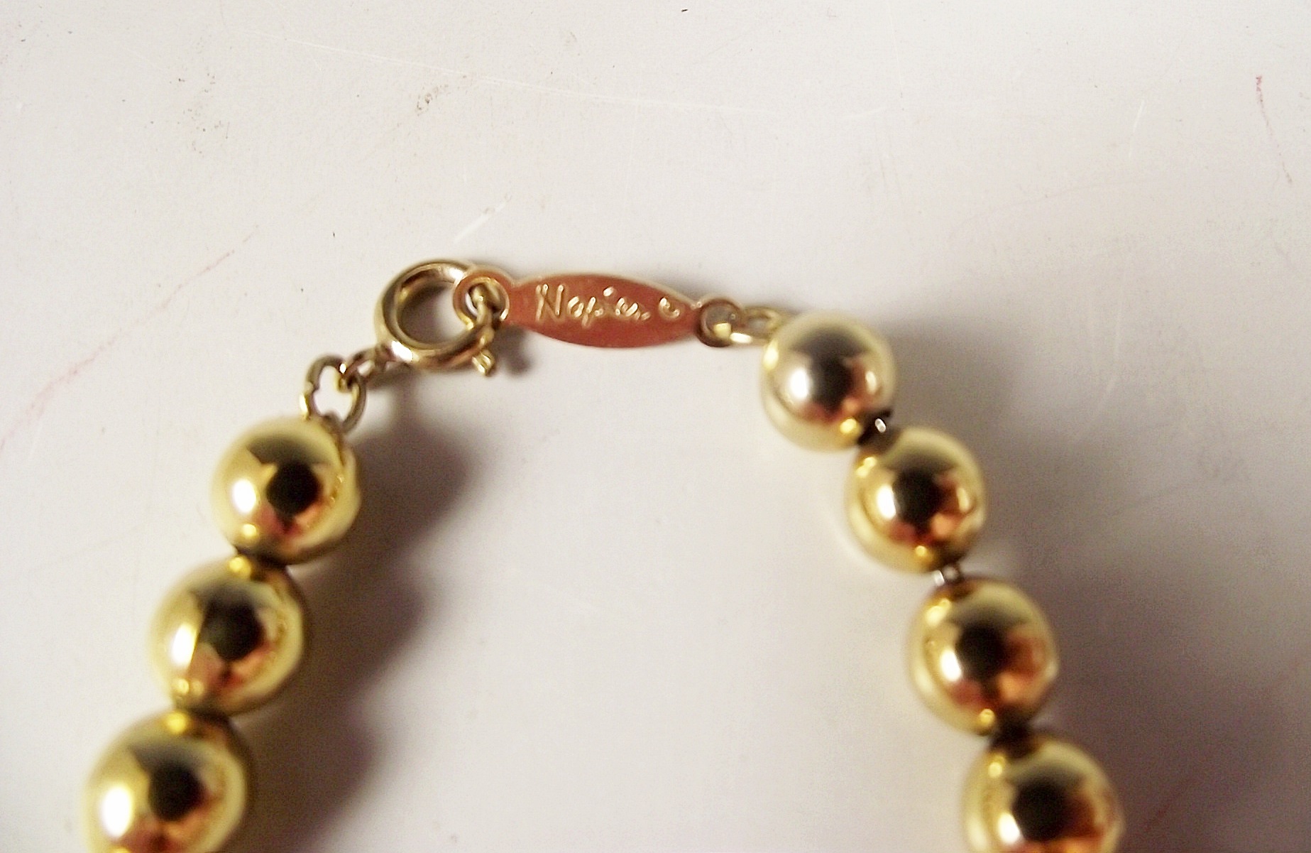 Four gold tone necklaces.