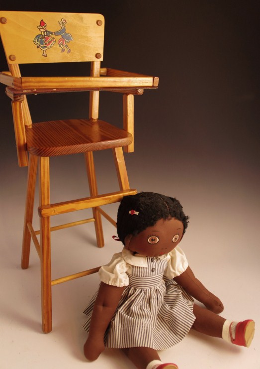 Vintage wooden high chair and rag doll with pin stripe dress