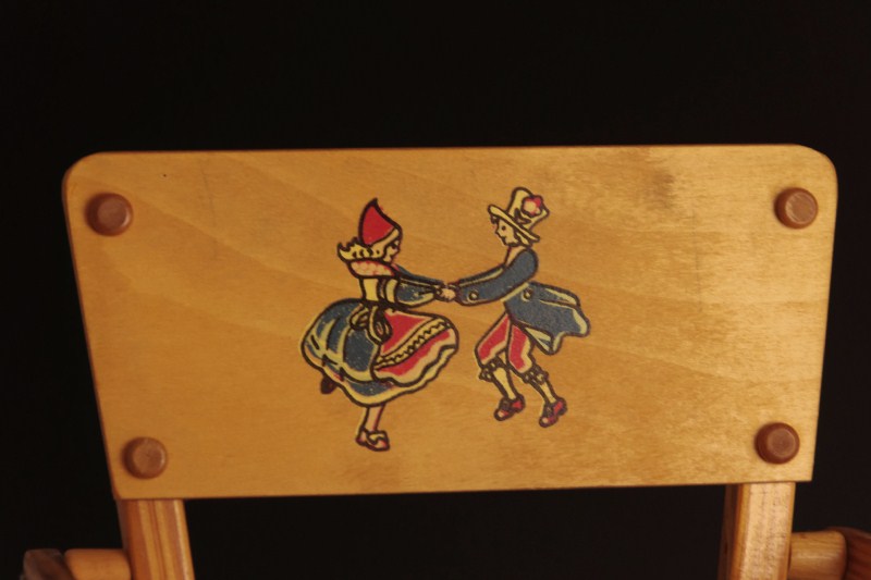 Vintage wooden high chair and rag doll with pin stripe dress