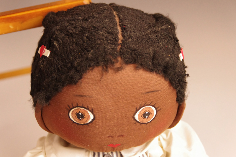 Vintage wooden high chair and rag doll with pin stripe dress