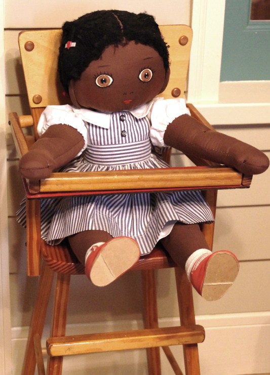 Vintage wooden high chair and rag doll with pin stripe dress