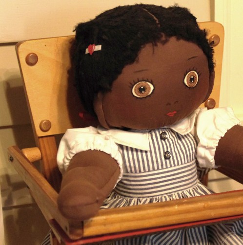 Vintage wooden high chair and rag doll with pin stripe dress